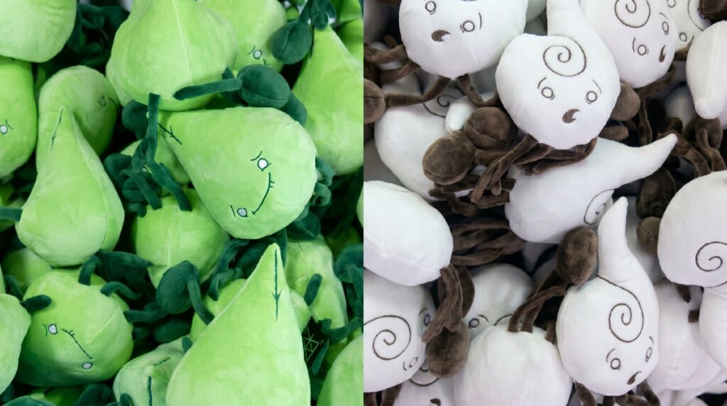 A detailed split-screen closeup showing the soft textures and embroidered faces of the green Earth and white Air elemental plushies in their final production bins.