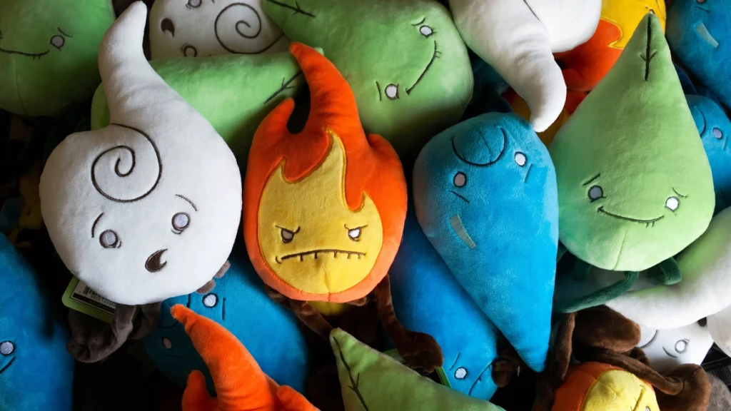 A colorful pile featuring the full collection of Raven Stitch Plush Elements: the grumpy orange Fire, the nervous blue Water, the smiling green Earth, and the surprised white Air spirits.