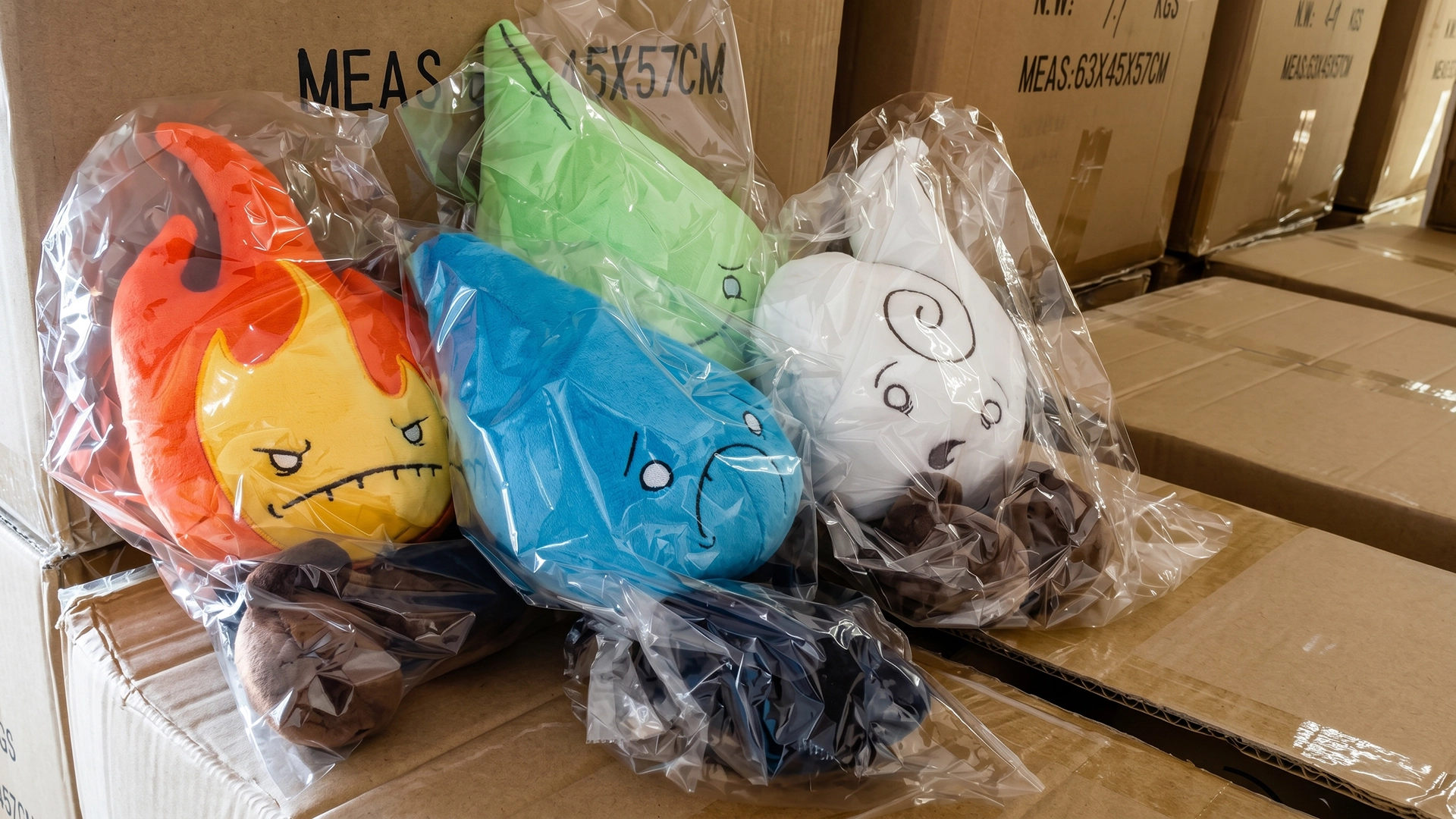 Individually bagged Fire, Water, Earth, and Air plush toys sitting on top of large cardboard shipping boxes in a storage facility.