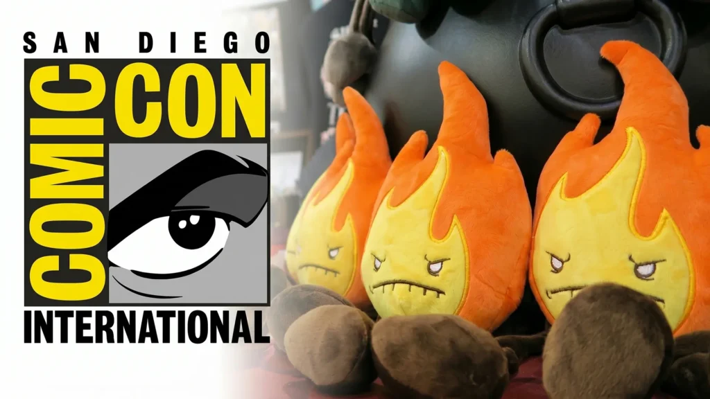 The San Diego Comic-Con International logo placed next to a row of three Fire Plush Elements sitting in front of a black cauldron.